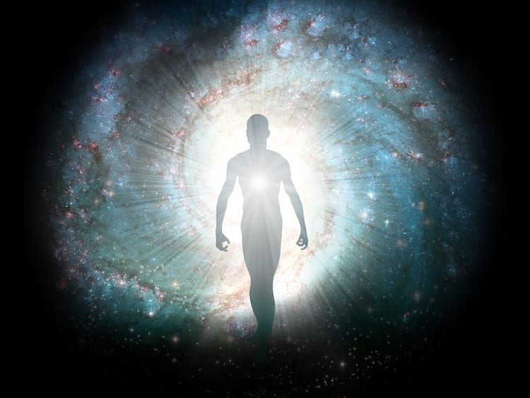 Shape of a person walking with a black background and swirling cosmic colors around them. 